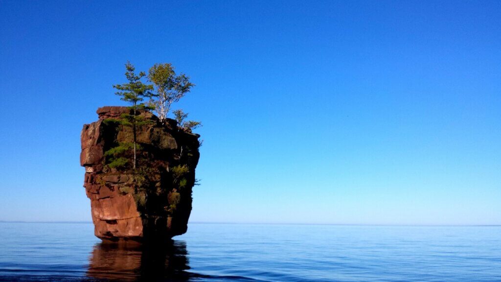 A standalone rock formation in Lake Superior near Stockton Island in Apostle Islands National Lakeshore. It is large, with tree