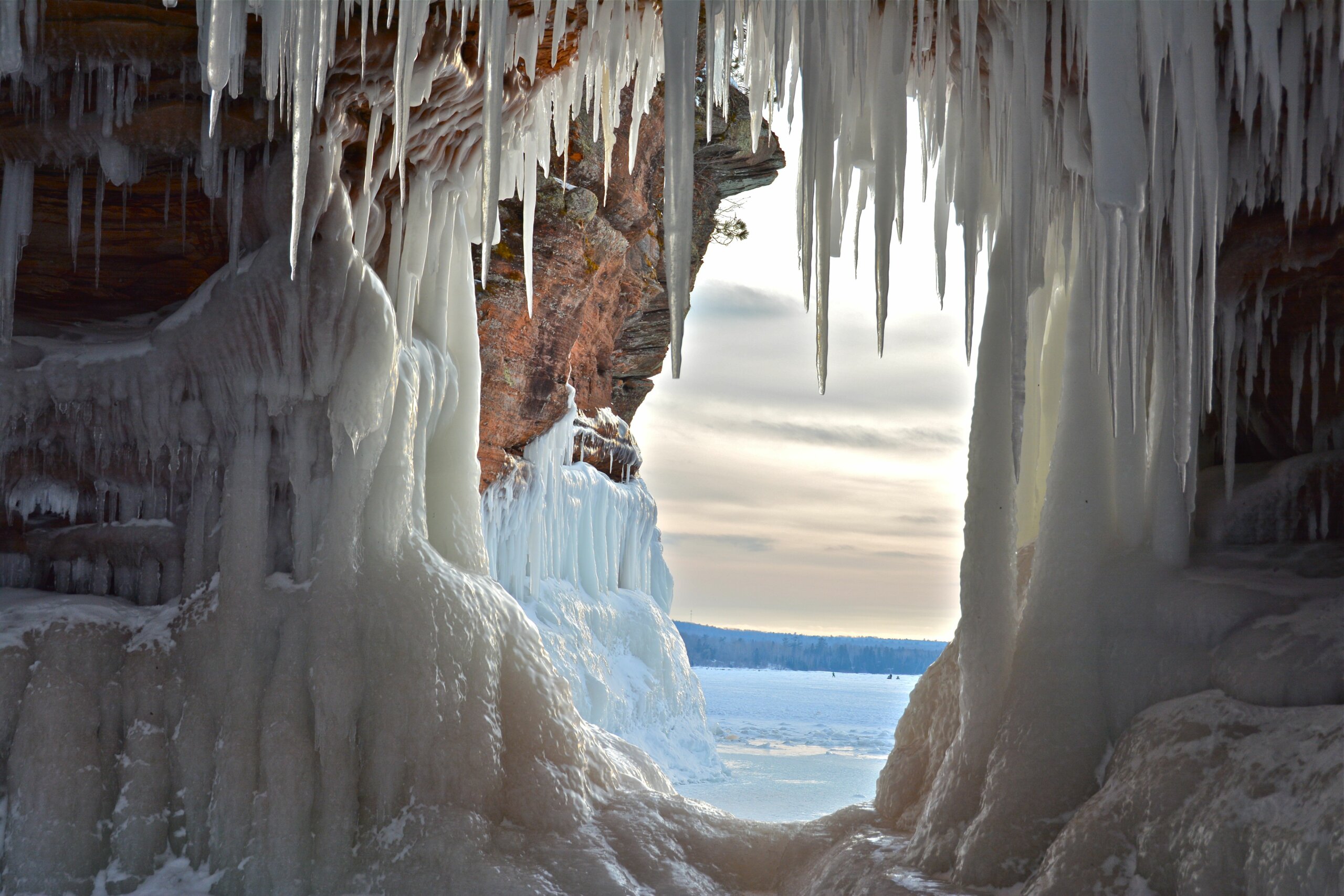 Caves from the inside in winter with snow and icicles hanging down.