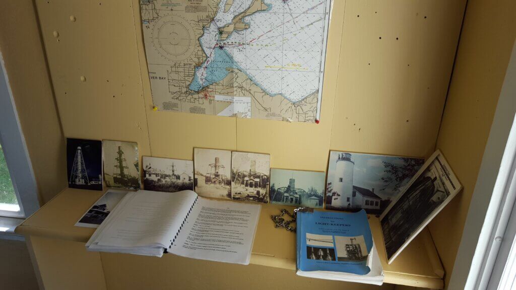 Yellow desk with a map on the wall and books and photographs on the desk.