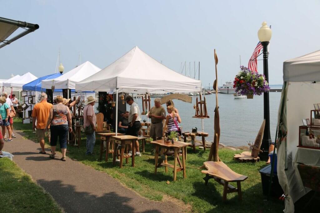 Outdoor arts fair along the water of a marina.