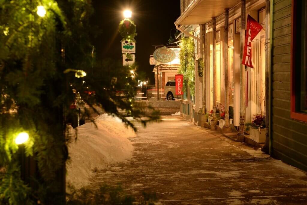 Cobbled street in a picturesque downtown at night filled with snow. 