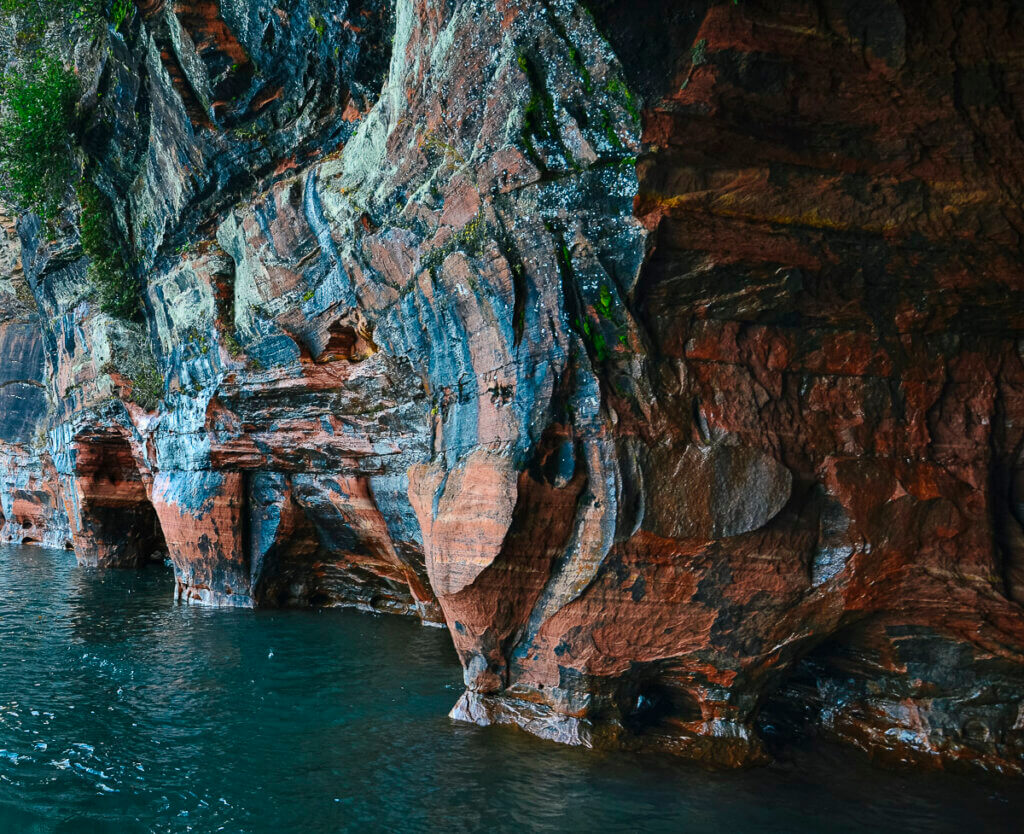 Highlight Number 7 of an Apostle Islands Cruises' Grand Tour: Red sandstone rock on the shoreline showing scarlet hues from iron