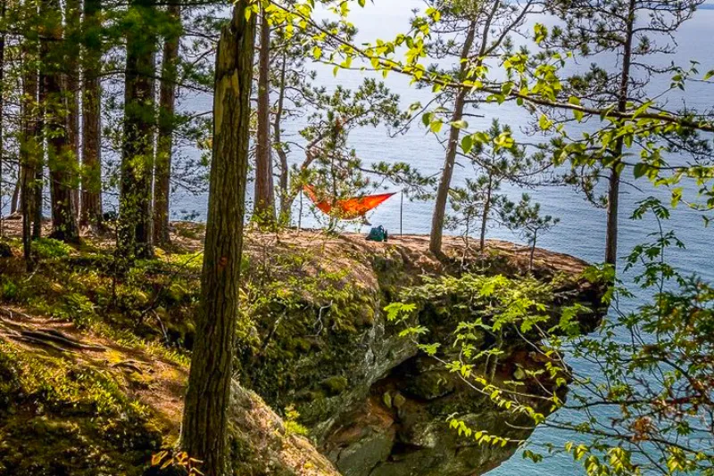 A person hammocks near the cliffs on an island in the Apostle Island National Lakeshore.