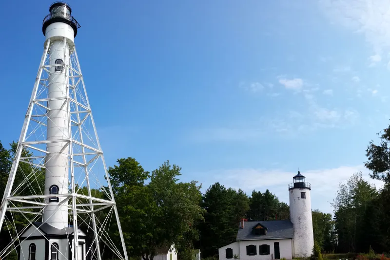 Michigan Island's twin, white lighthouses. One is tall on the left while the other is shorter on the right.