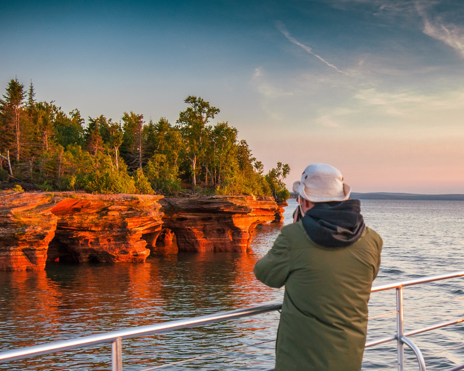 A baby deer is tucked up next to a log in Apostle Islands, Wisconsin's Crown Jewels.